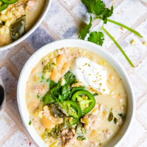 beige ceramic bowls filled with white chicken chili made in the Instant Pot and garnished with jalapenos