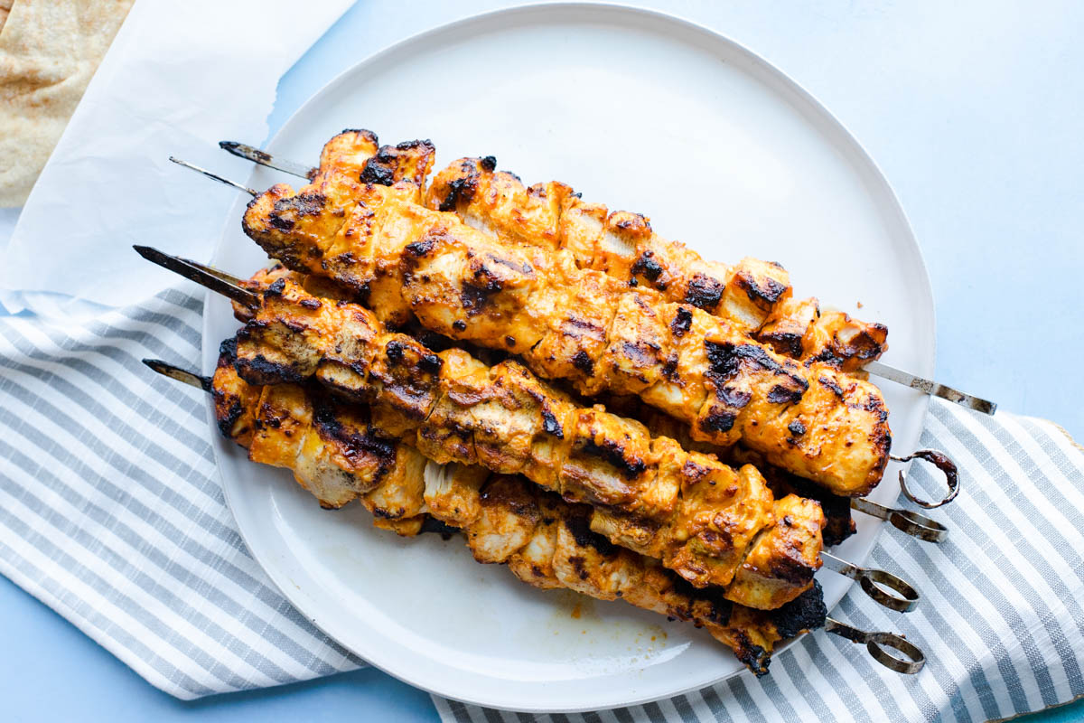 freshly grilled chicken shawarma kebabs on a white plate