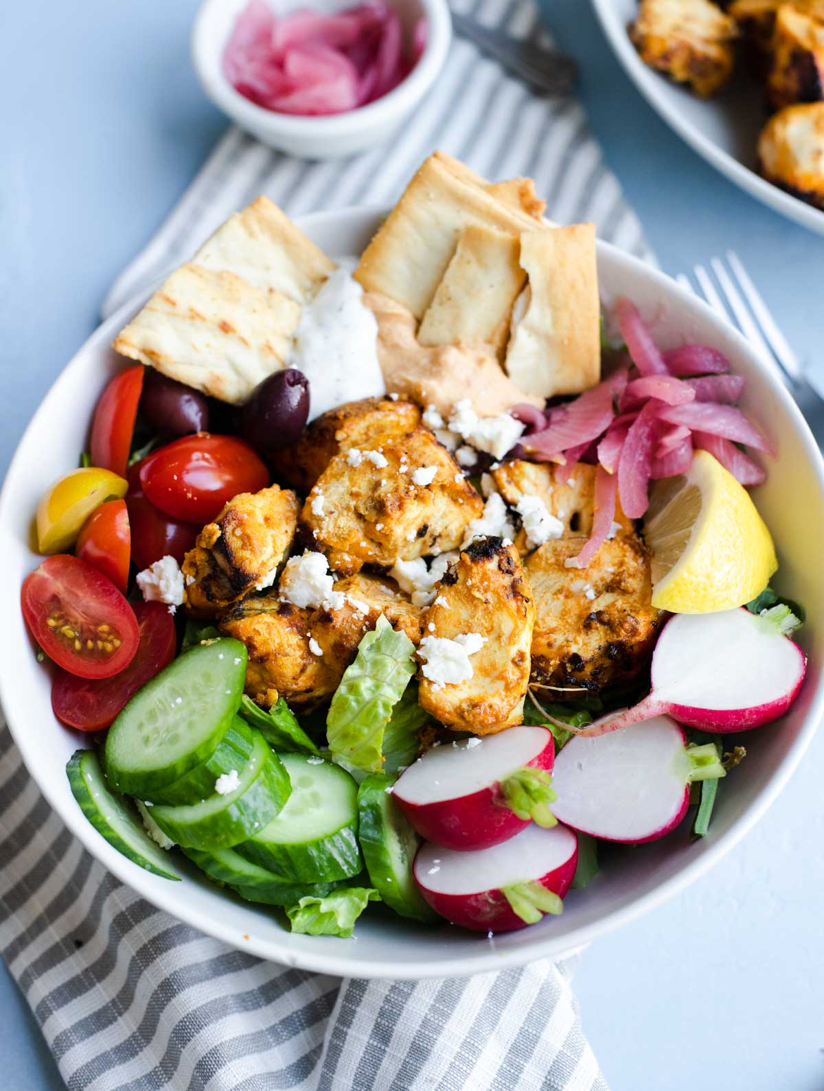 grilled chicken shawarma in a veggie loaded bowl garnished with feta cheese 