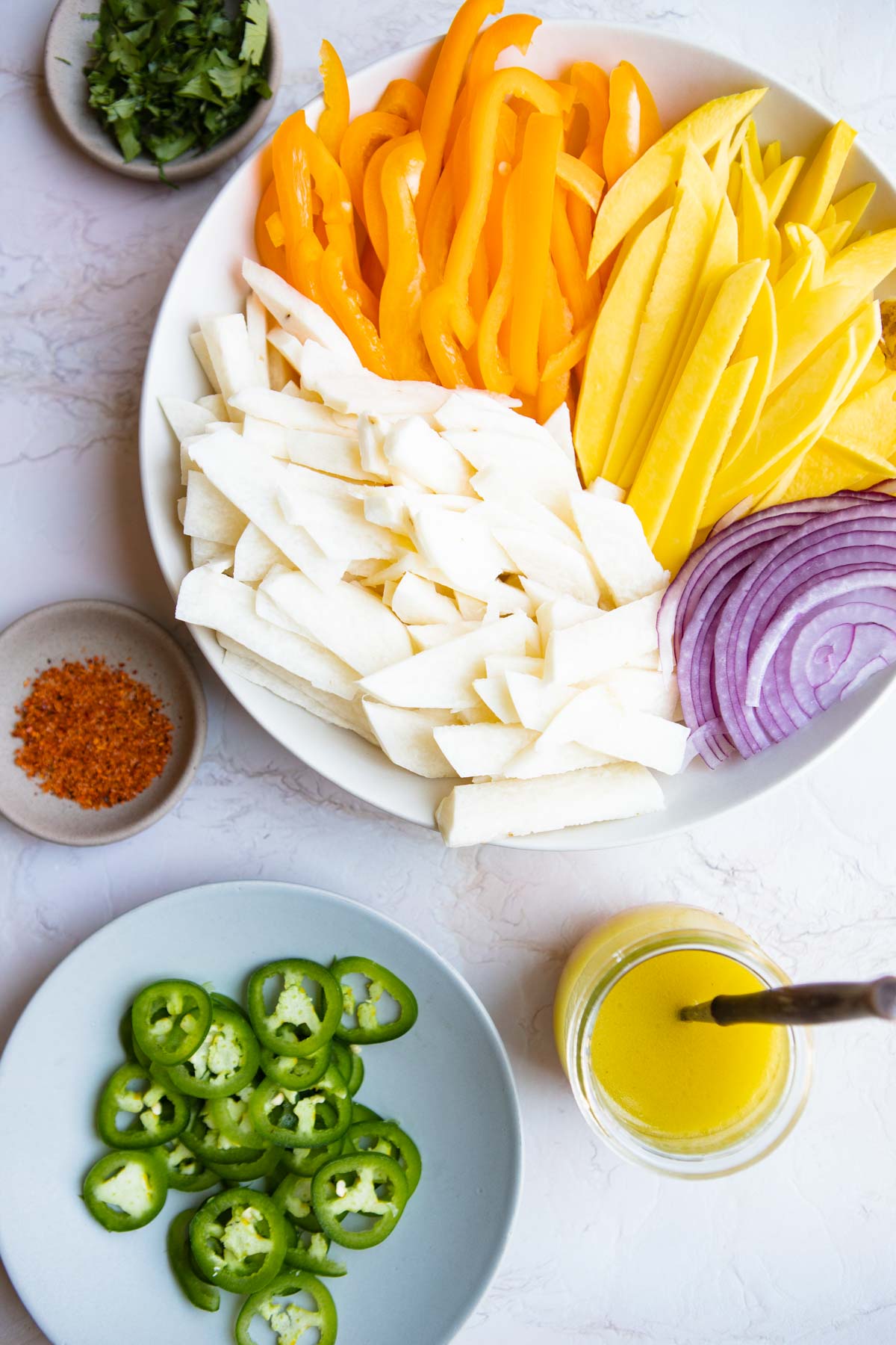 ingredients to make a jicama and mango salad on a serving platter