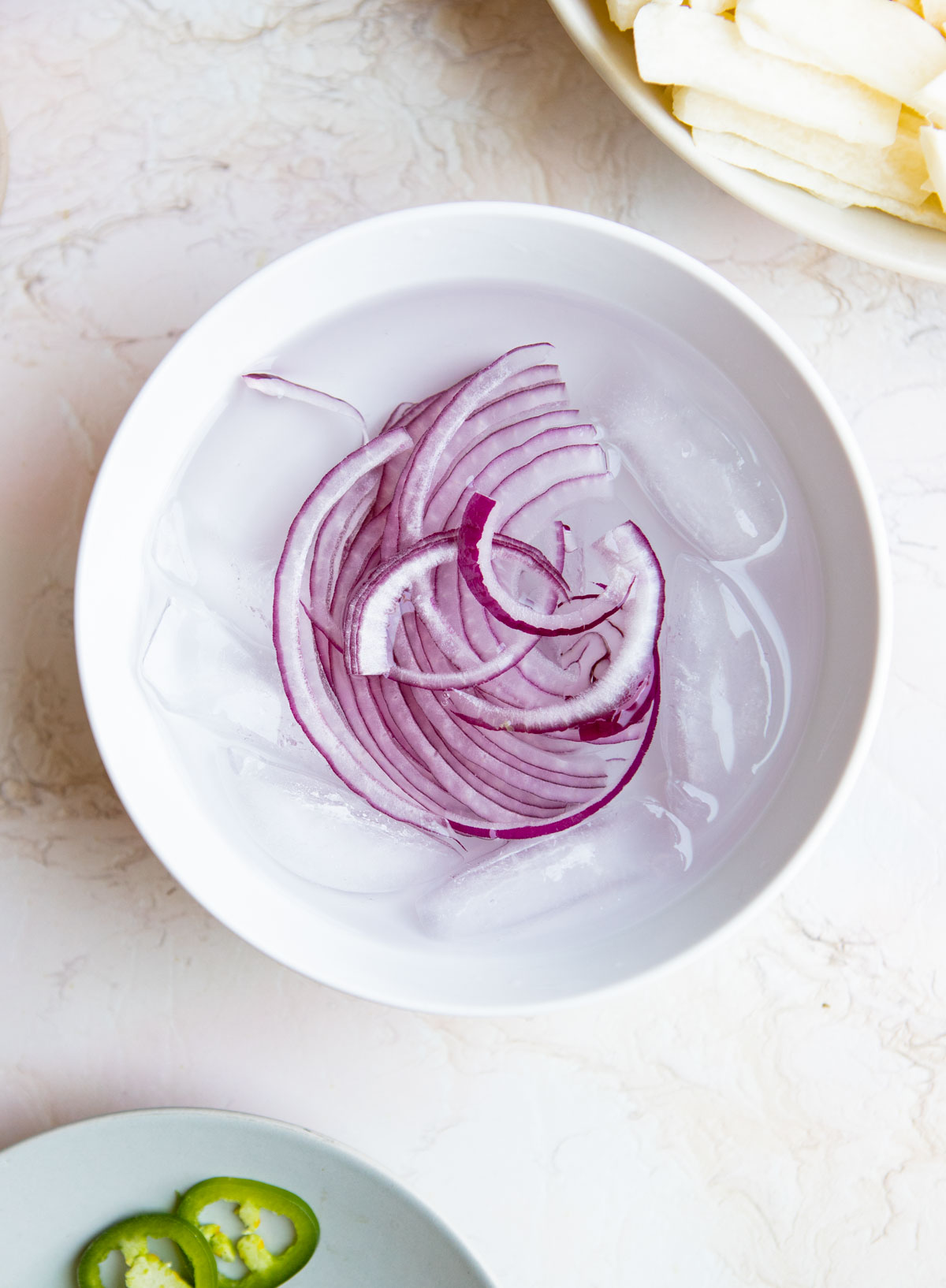 sliced red onions soaking in ice water