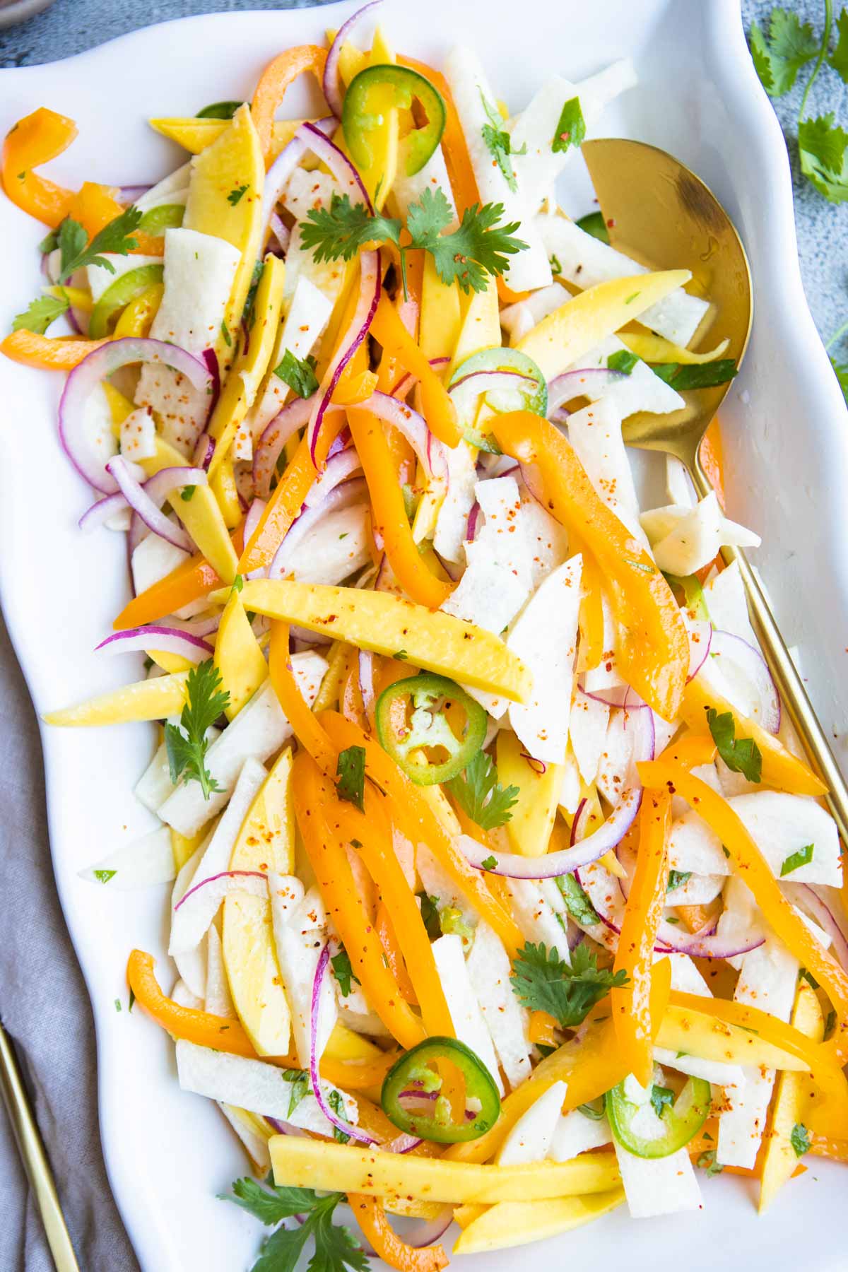 jicama mango salad on a white serving dish