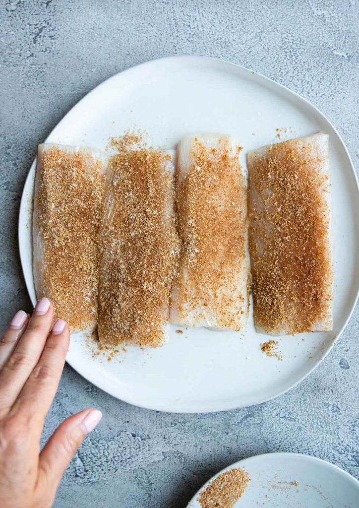 raw mahi mahi fillets covered in a dry rub seasoning 