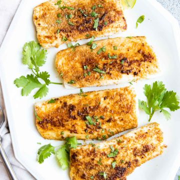 white platter with 4 pan seared mahi mahi fillets garnished with cilantro