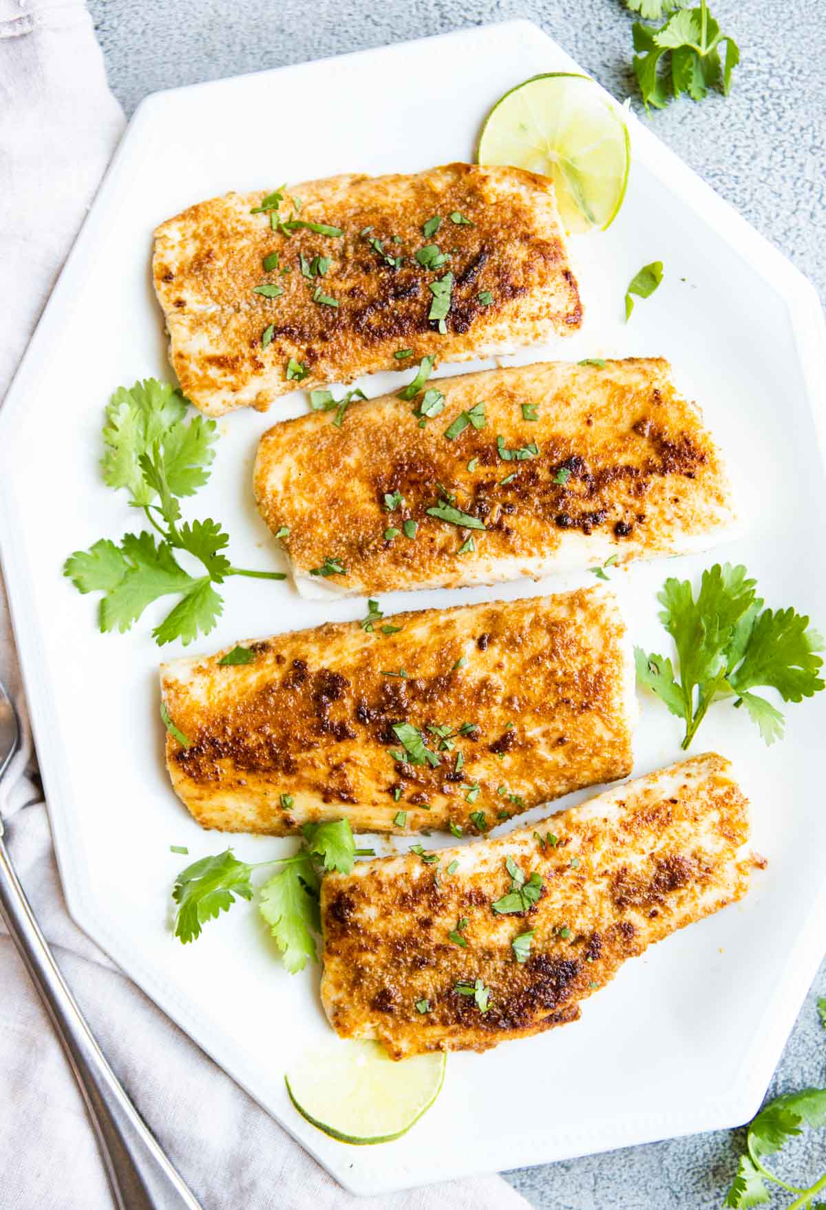 white platter with 4 pan seared mahi mahi fillets garnished with cilantro 