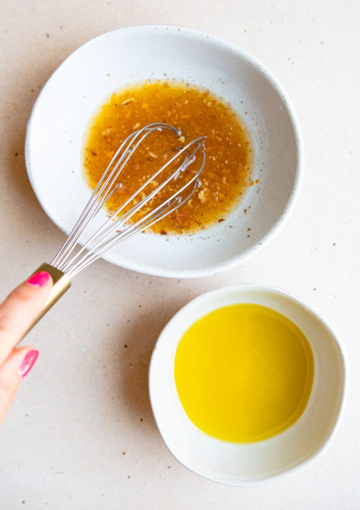 olive oil and orange juice plus cinnamon and salt being prepared to make a vinaigrette