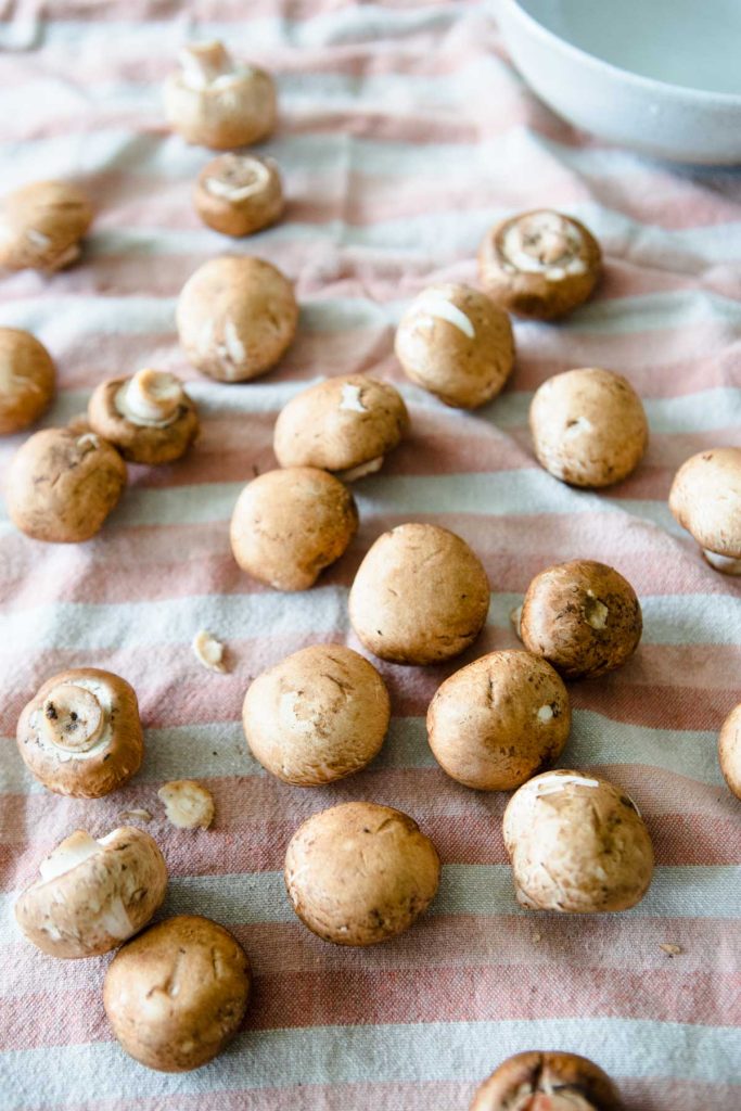 baby bella mushrooms air drying on a kitchen towel