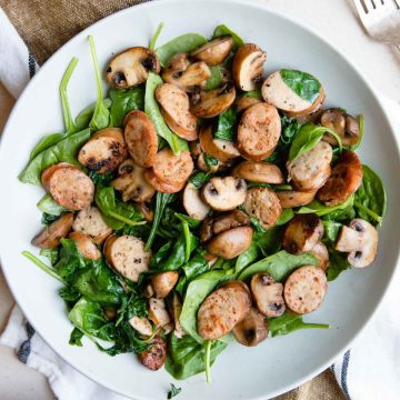 gray bowl filled with a sausage breakfast skillet made with mushrooms and spinach