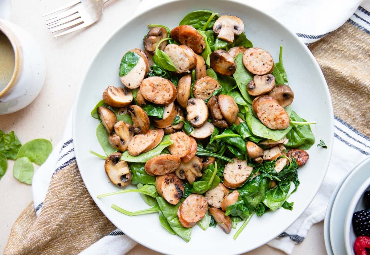 sausage breakfast skillet in a gray dish filled with a cooked sausage breakfast skillet dish, made with mushrooms and spinach