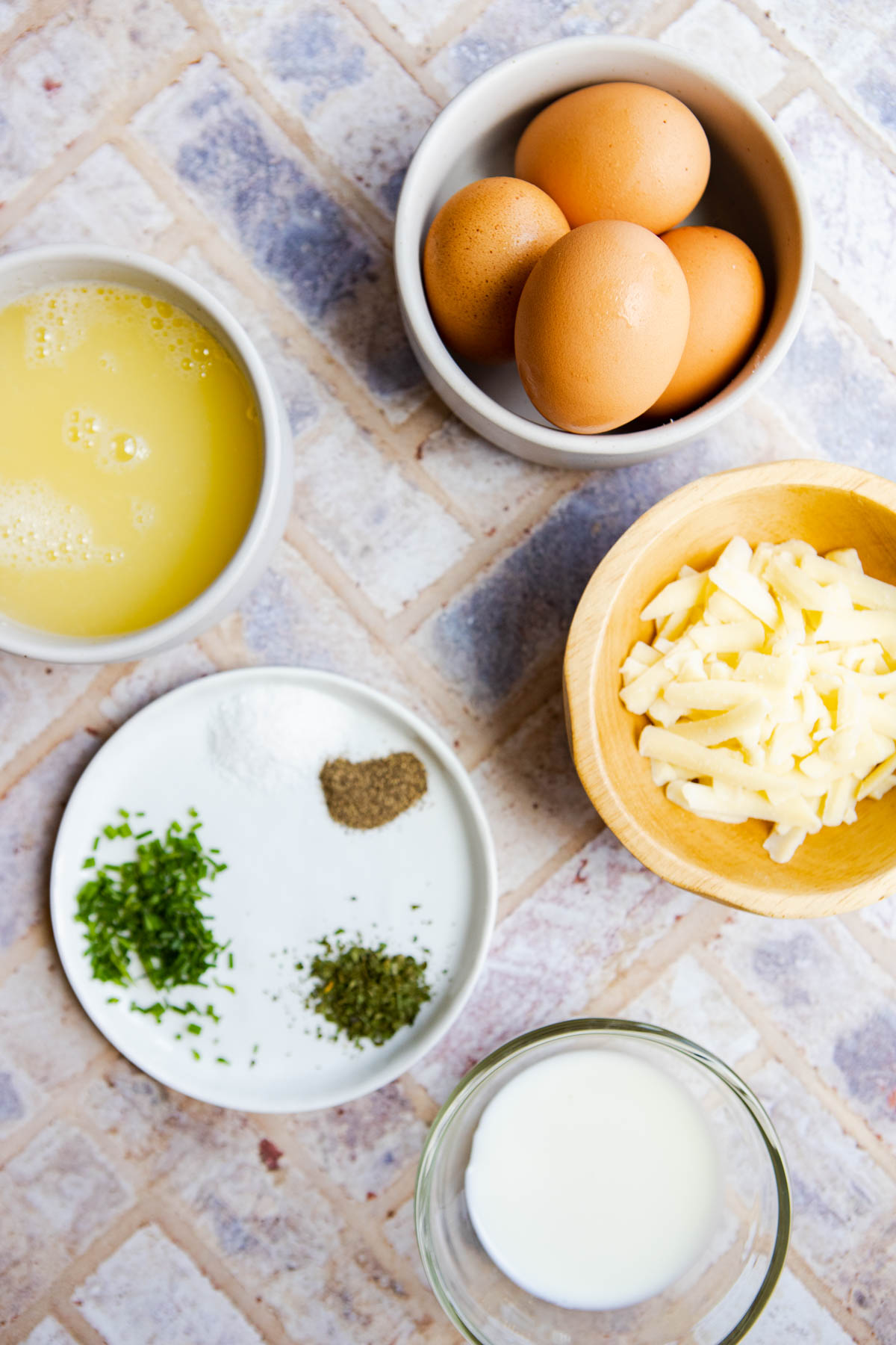 raw eggs and egg whites plus cheese, milk and herbs to make sheet pan eggs for breakfast sandwiches