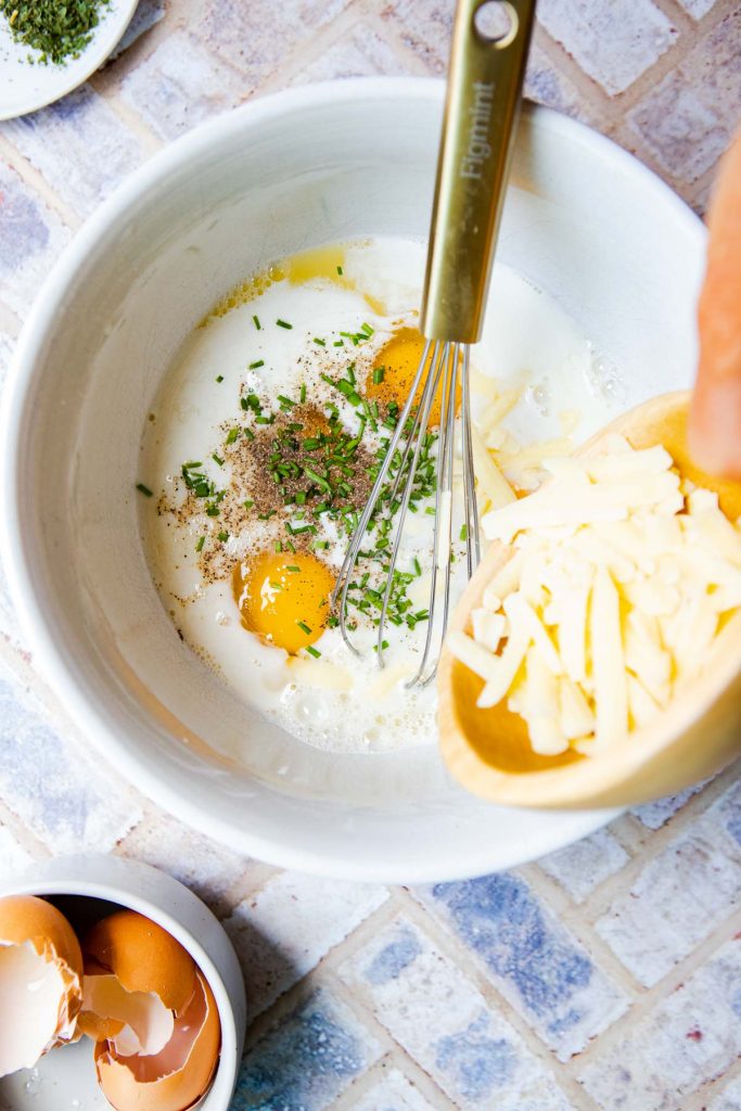 eggs, egg whites and milk and cheese added to a large mixing bowl