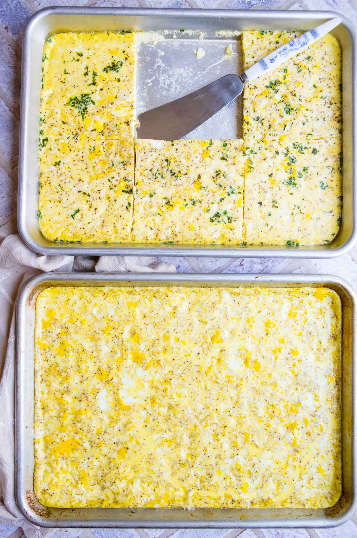 2 quarter sheet pans filled with baked sheet pan eggs for breakfast sandwiches 