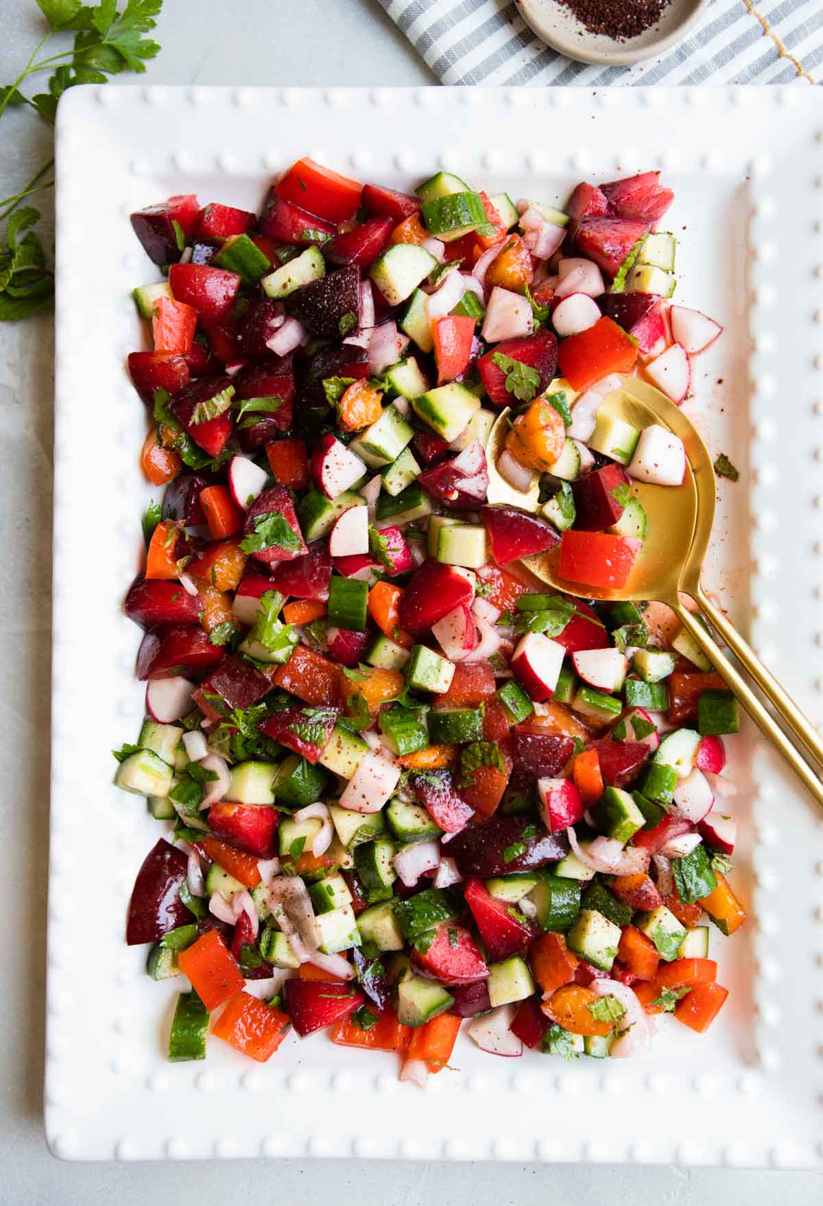 white platter filled with a plum and apricot salad sweetened with a honey lemon vinaigrette