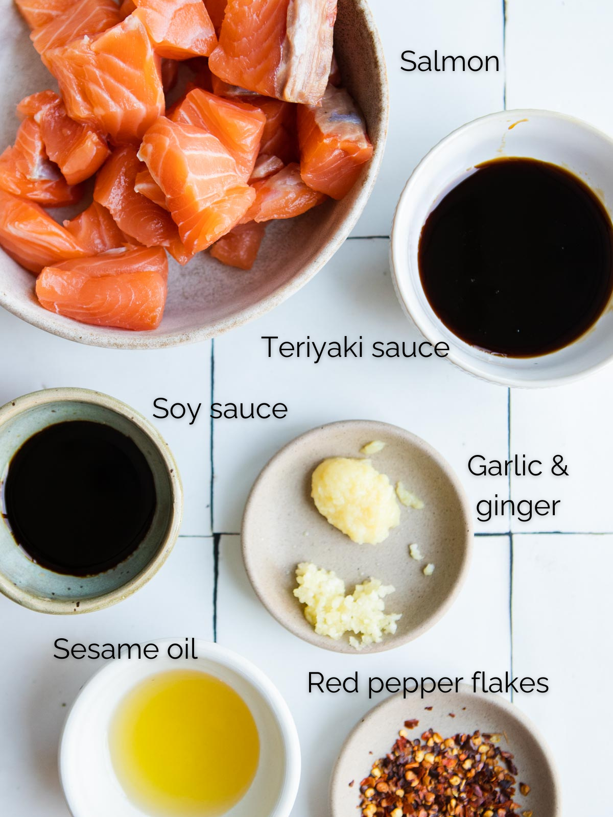 raw salmon pieces, teriyaki sauce, soy sauce, ginger and garlic, sesame oil and red pepper flakes in small bowls 