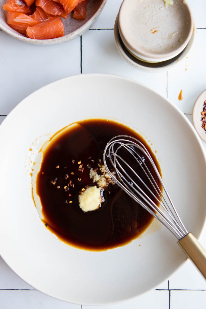 teriyaki marinade with fresh garlic and ginger in a shallow white bowl with a whisk