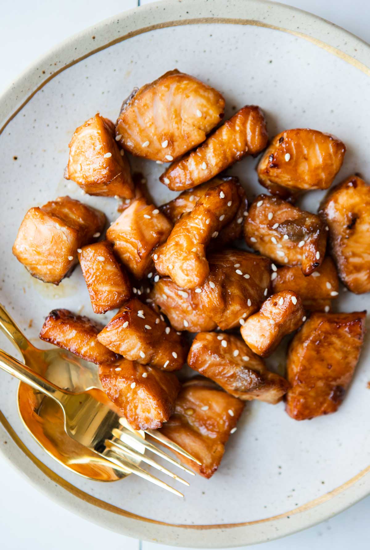 air fryer teriyaki salmon cooked and placed on a beige plate with a gold fork