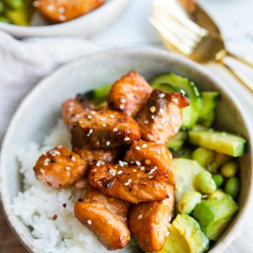 a beige bowl filled with white rice edamame salad and teriyaki salmon air fryer bites