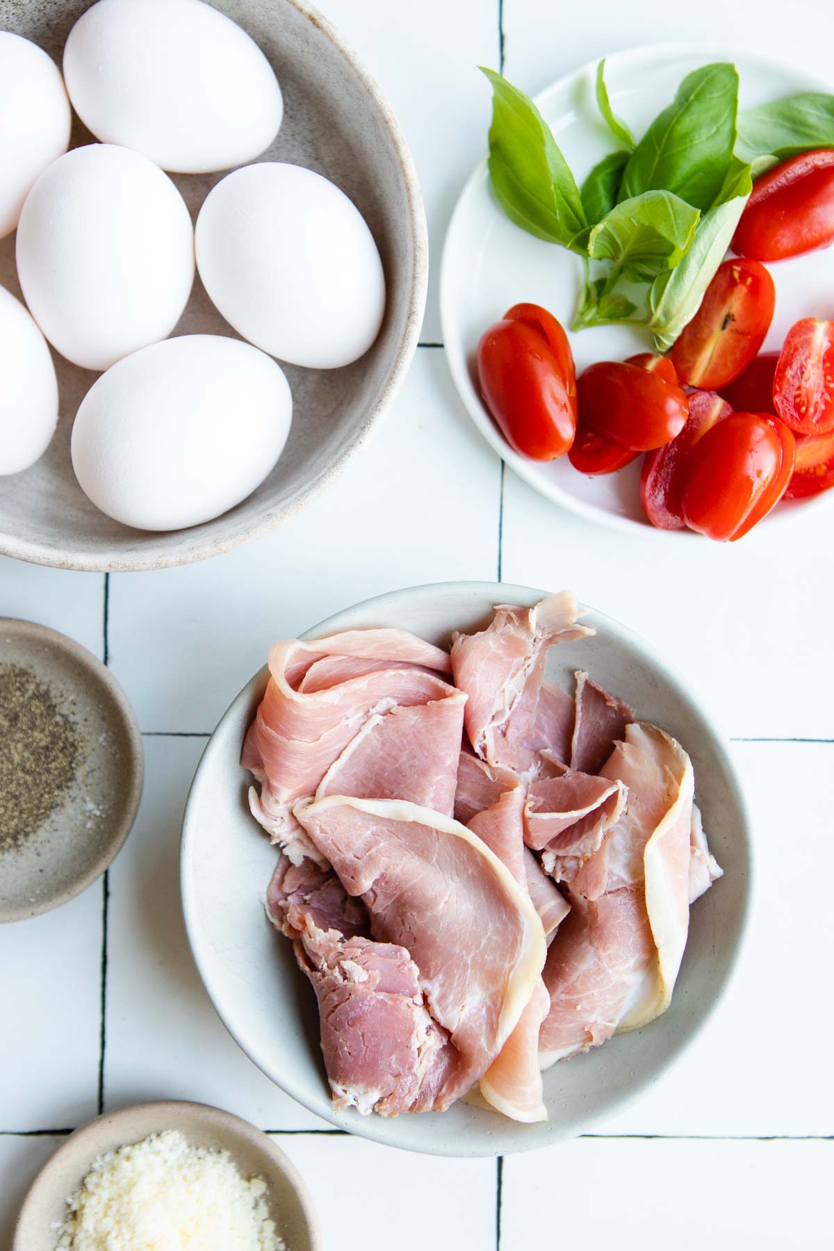 ingredients to make prosciutto egg cups in small white bowls