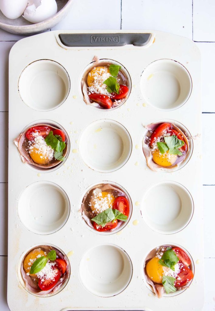 uncooked egg cups in a muffin tin ready to be baked