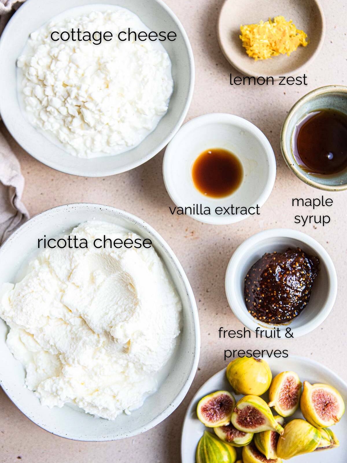 ricotta cheese, cottage cheese, lemon zest, vanilla, maple syrup and fresh figs and fig preserves in small white bowls