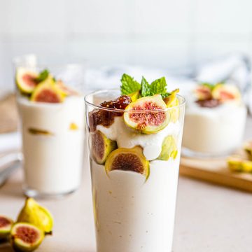 3 glasses filled with a ricotta cheese dessert layered with figs and fig preserves