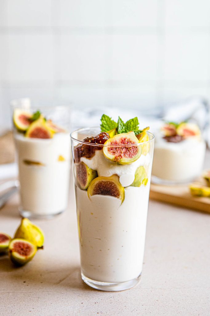 3 glasses filled with a ricotta cheese dessert layered with figs and fig preserves