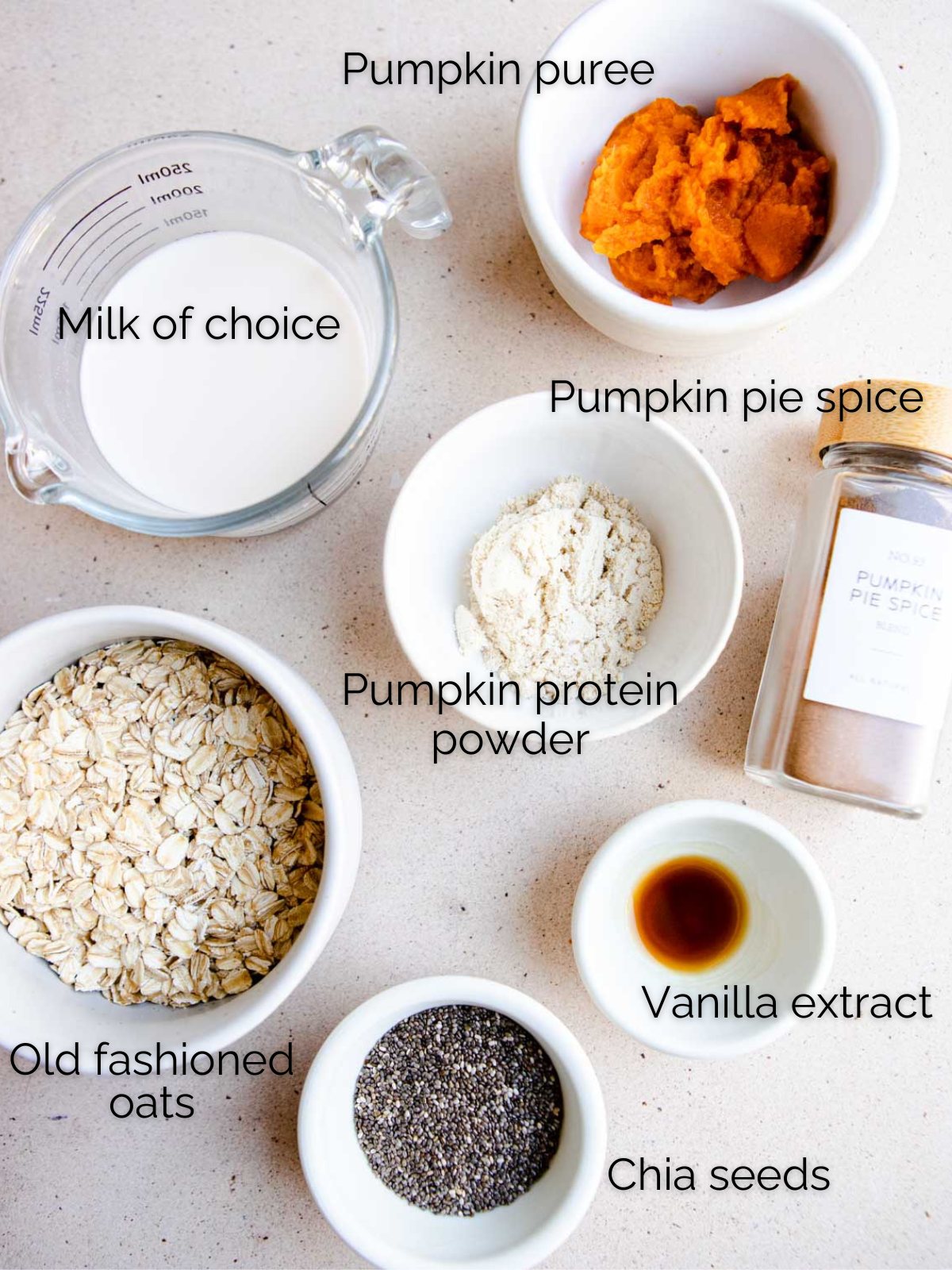 ingredients to make pumpkin spice overnight oats in small white bowls