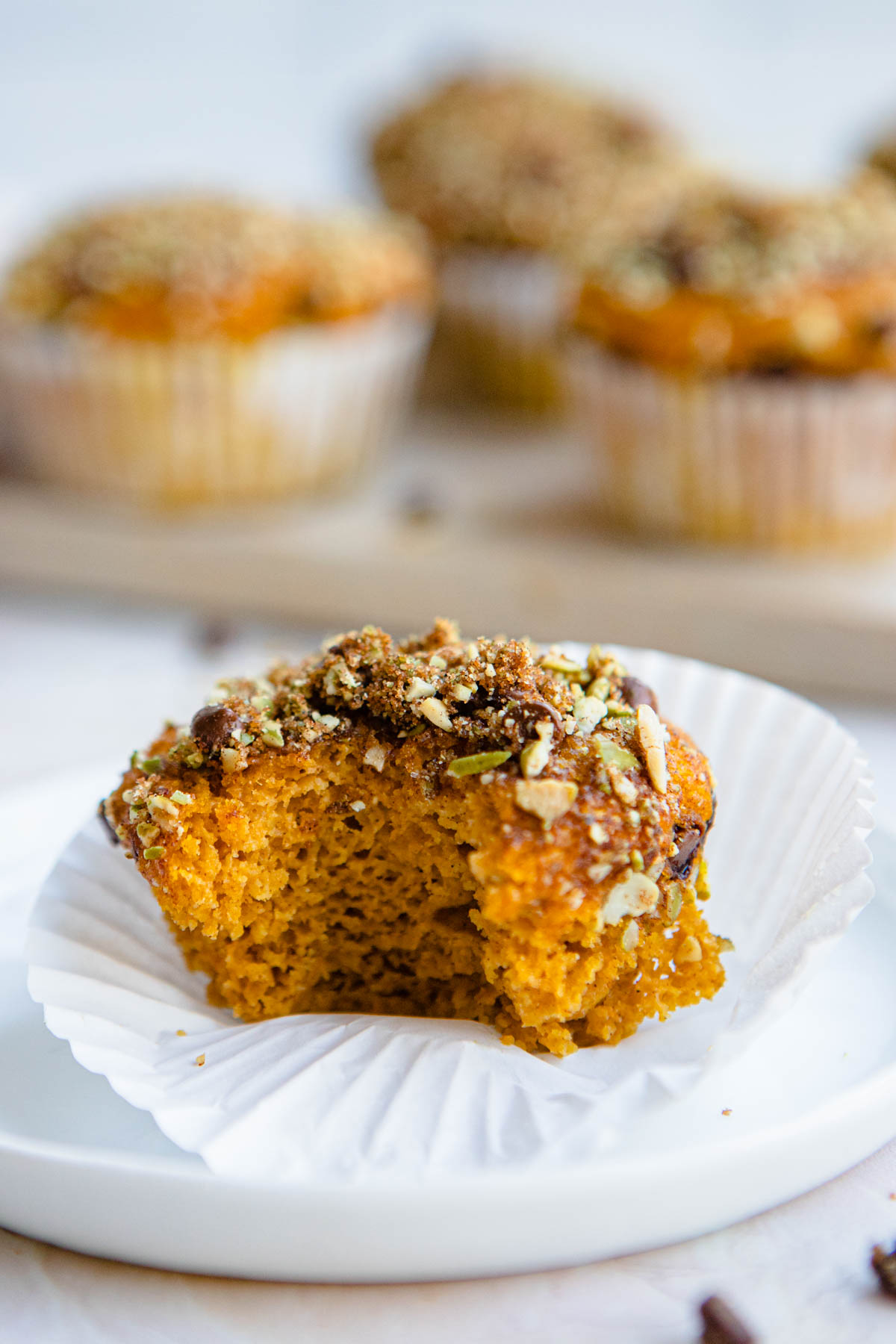 a pumpkin protein muffin with a bite taken out of it