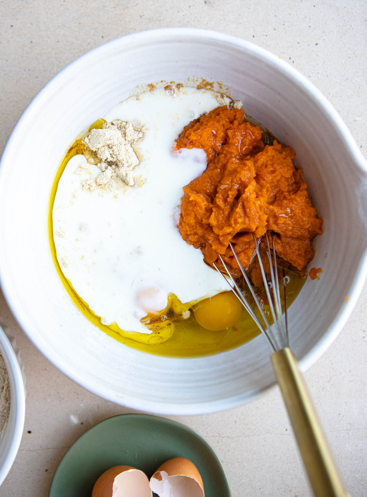 pumpkin puree and other ingredients combined in a white mixing bowl