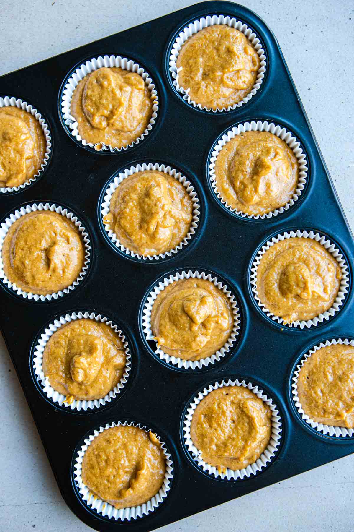 protein muffins pumpkin flavored batter in paper lined muffin tin