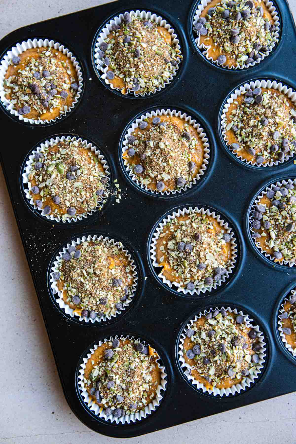 raw pumpkin protein muffins with a dark chocolate and pepita streusel topping 