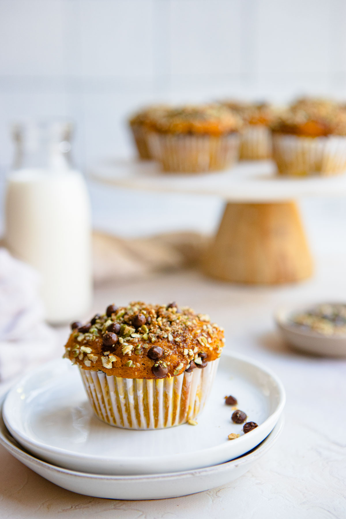 a cake stand and small white plate filled with pumpkin protein muffins