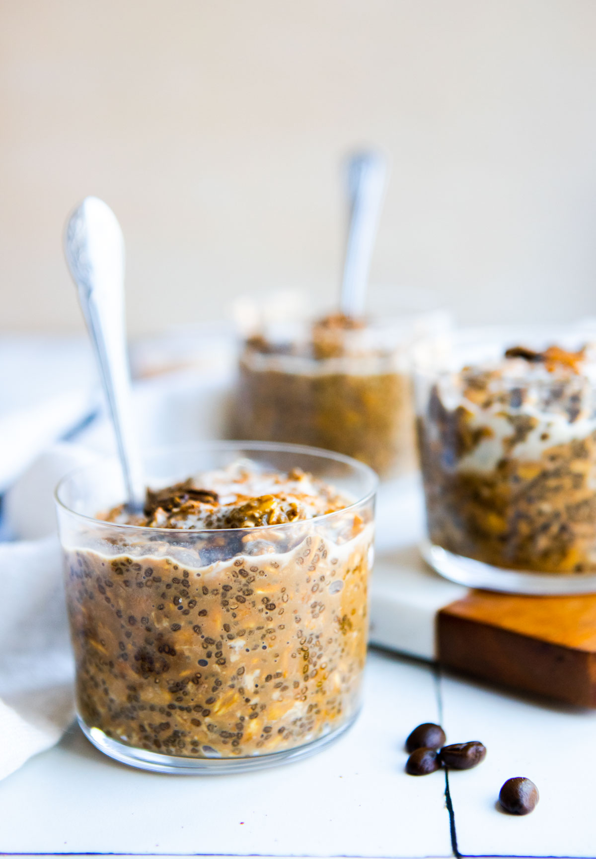 3 small glass jars of coffee overnight oats topped with espresso beans