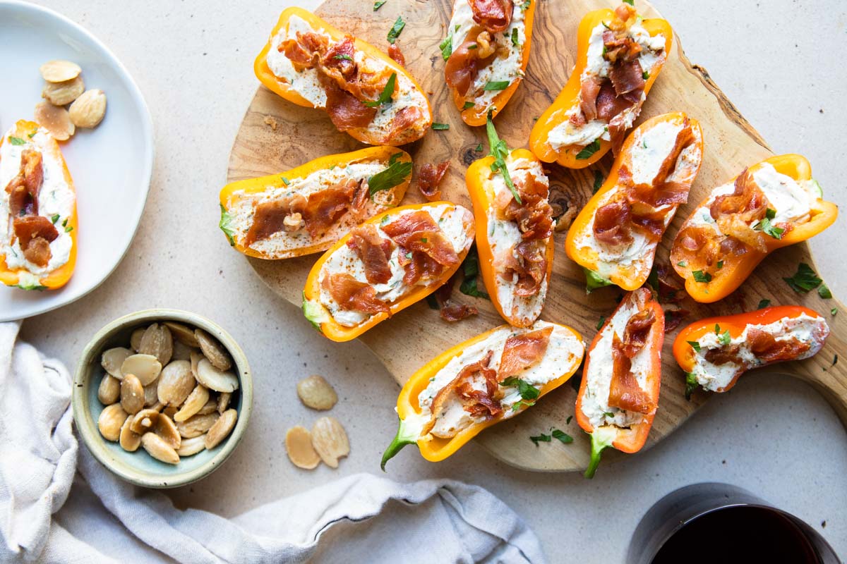 a wood board with goat cheese stuffed peppers on top