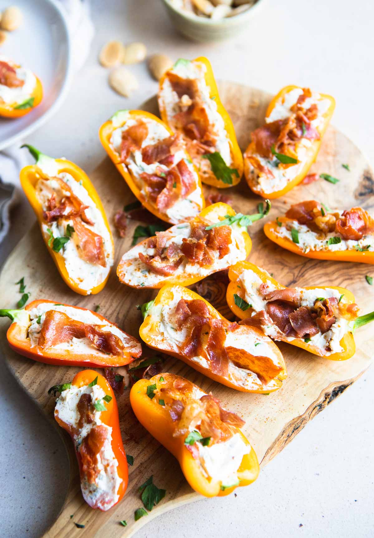 a wood cutting board topped with goat cheese stuffed peppers 