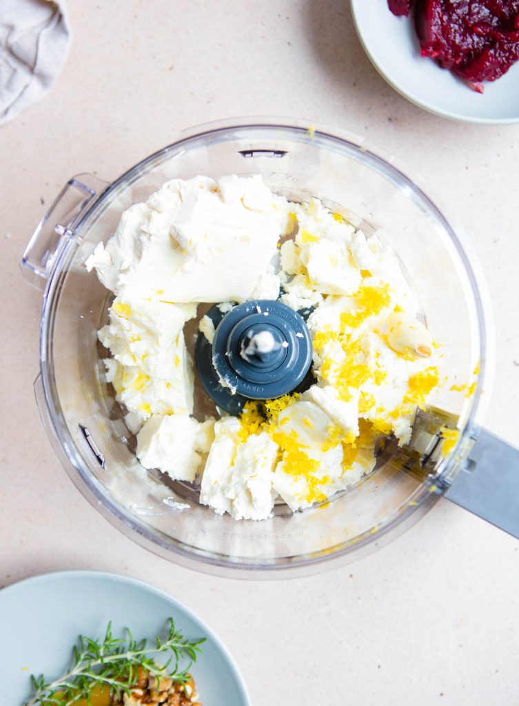 feta and cream cheese and lemon zest in the bowl of a food processor 