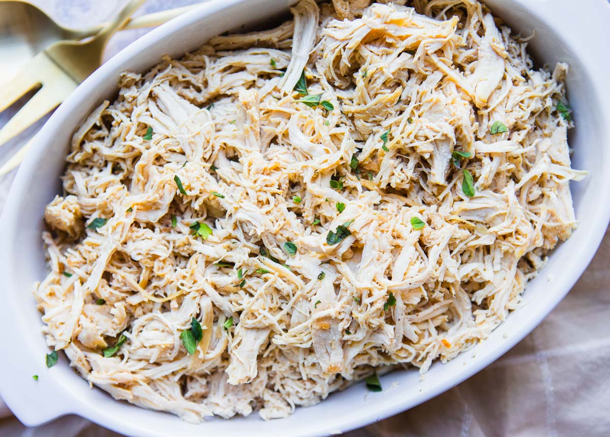 white ceramic dish filled with shredded chicken made in the dutch oven