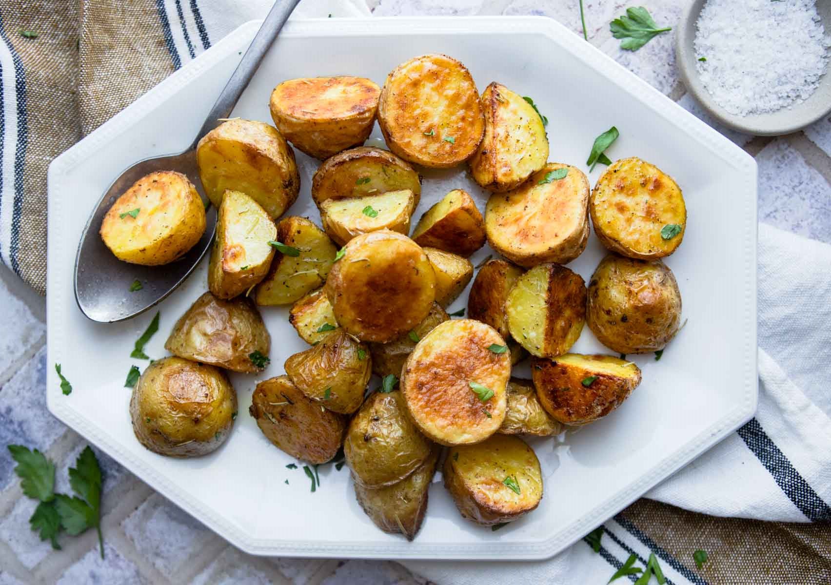 roasted yellow baby potatoes on a white ceramic dish