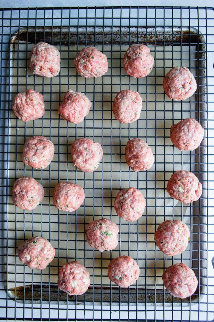 uncooked meatballs on a baking tray ready to bake 