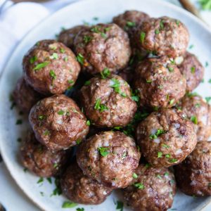 a plate filled with Greek lamb meatballs and garnished with fresh parsley