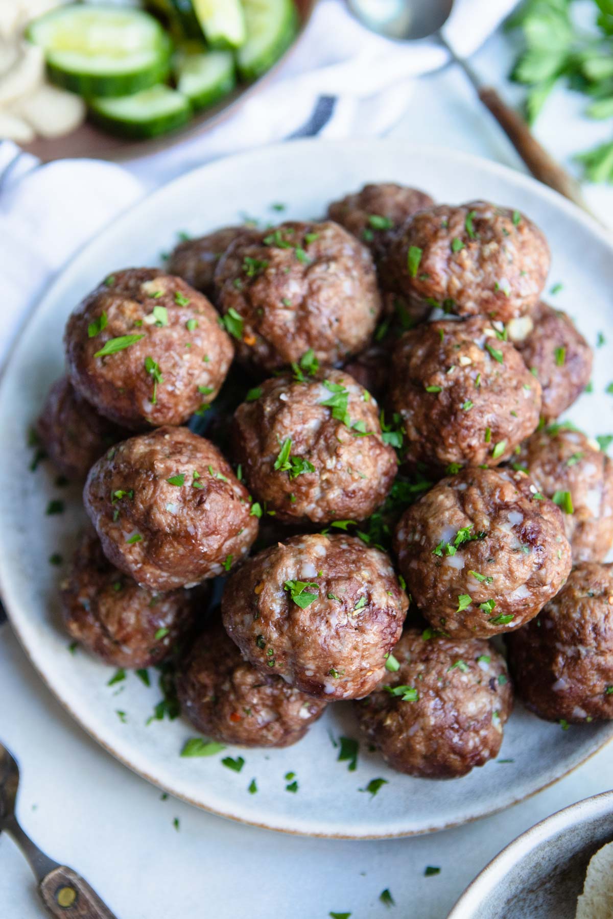 a plate filled with Greek lamb meatballs and garnished with fresh parsley 