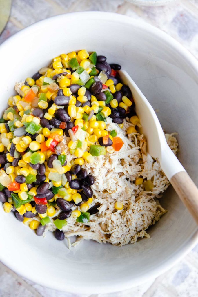 mixed veggies and shredded chicken in a white ceramic bowl