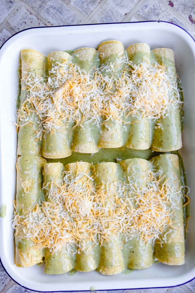 healthy enchiladas covered with green chili sauce ready to bake