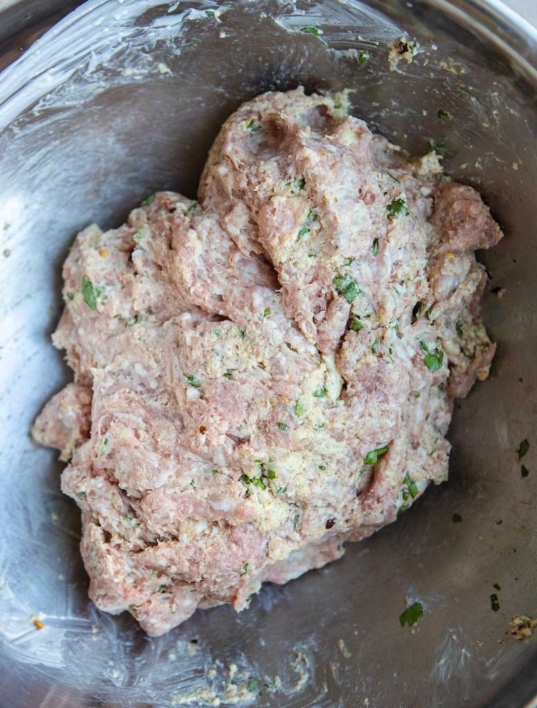 ground lamb and ground beef along with herbs and spices mixed up ready to make meatballs