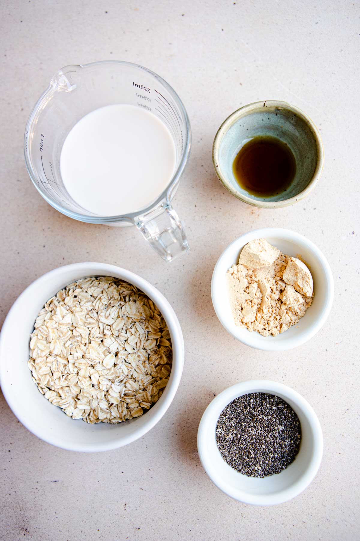 ingredients to make overnight peanut butter oats in small white bowls