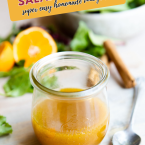 orange vinaigrette in a small jar next to salad greens