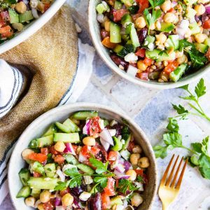 2 cream bowls filled with Mediterranean chopped salad and garnished with parsley