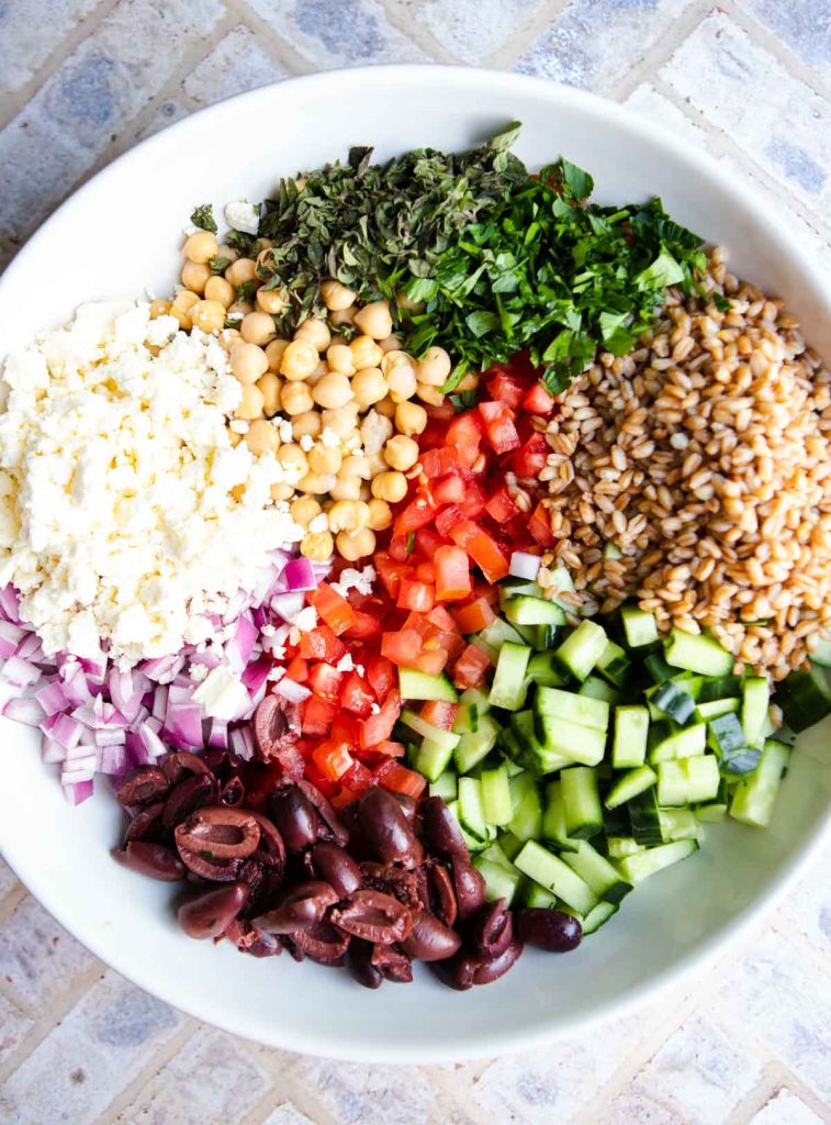 Chopped Mediterranean salad ingredients in a large white serving bowl